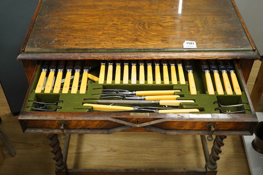 A 1920’s canteen of Old English pattern flatware, housed in a Queen Anne style oak cabinet, 87cm high